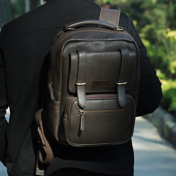 Person wearing a dark leather backpack outdoors
