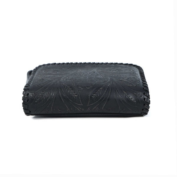 Black leather clutch with floral embossing on a white background