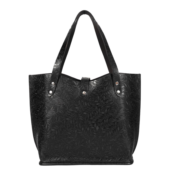 A black leather tote bag with embossed floral patterns and silver hardware.