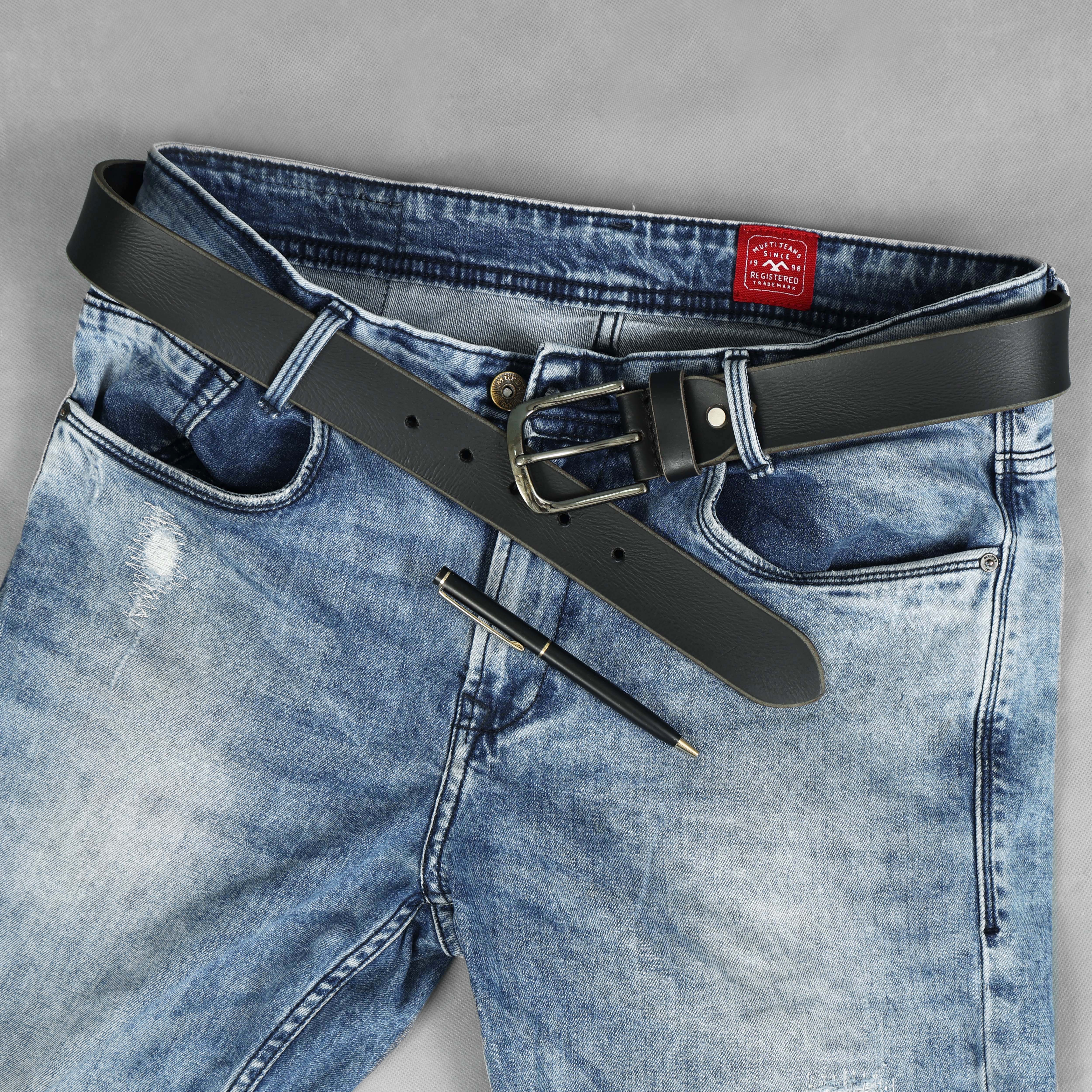Blue jeans with a black belt and pen on a gray background