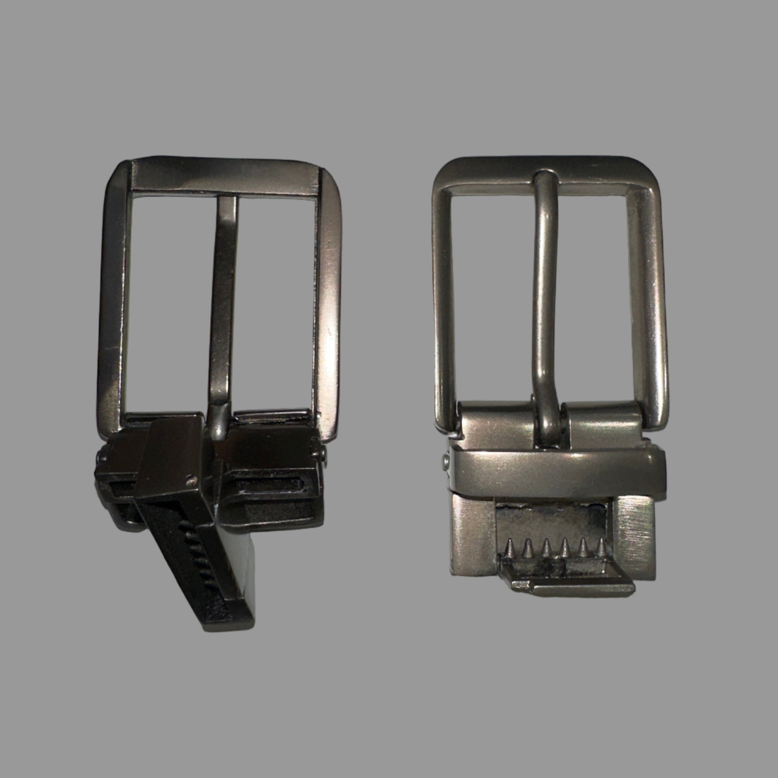 Two belt buckles, one silver and one black, on a light gray background.