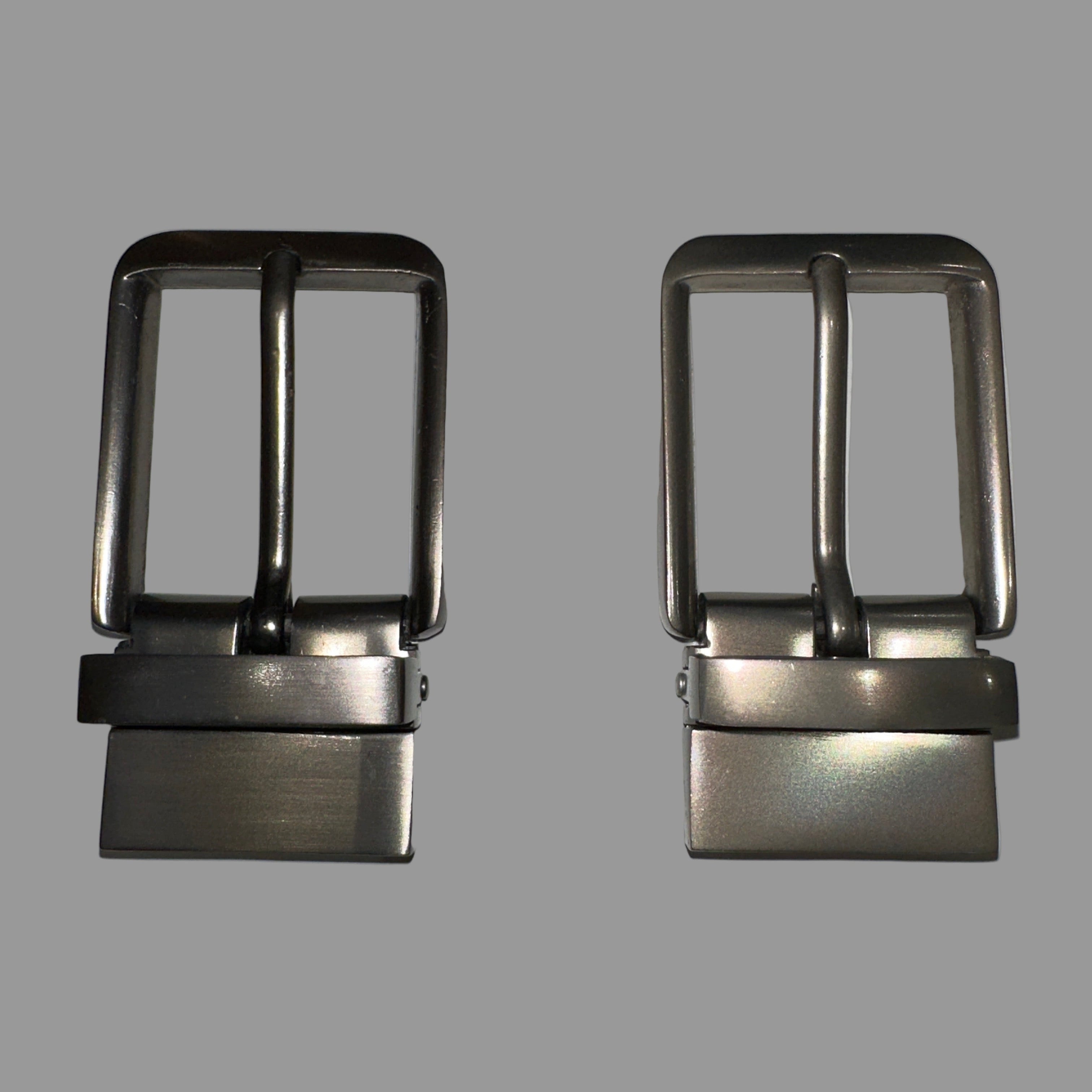 Two metal belt buckles on a light gray background