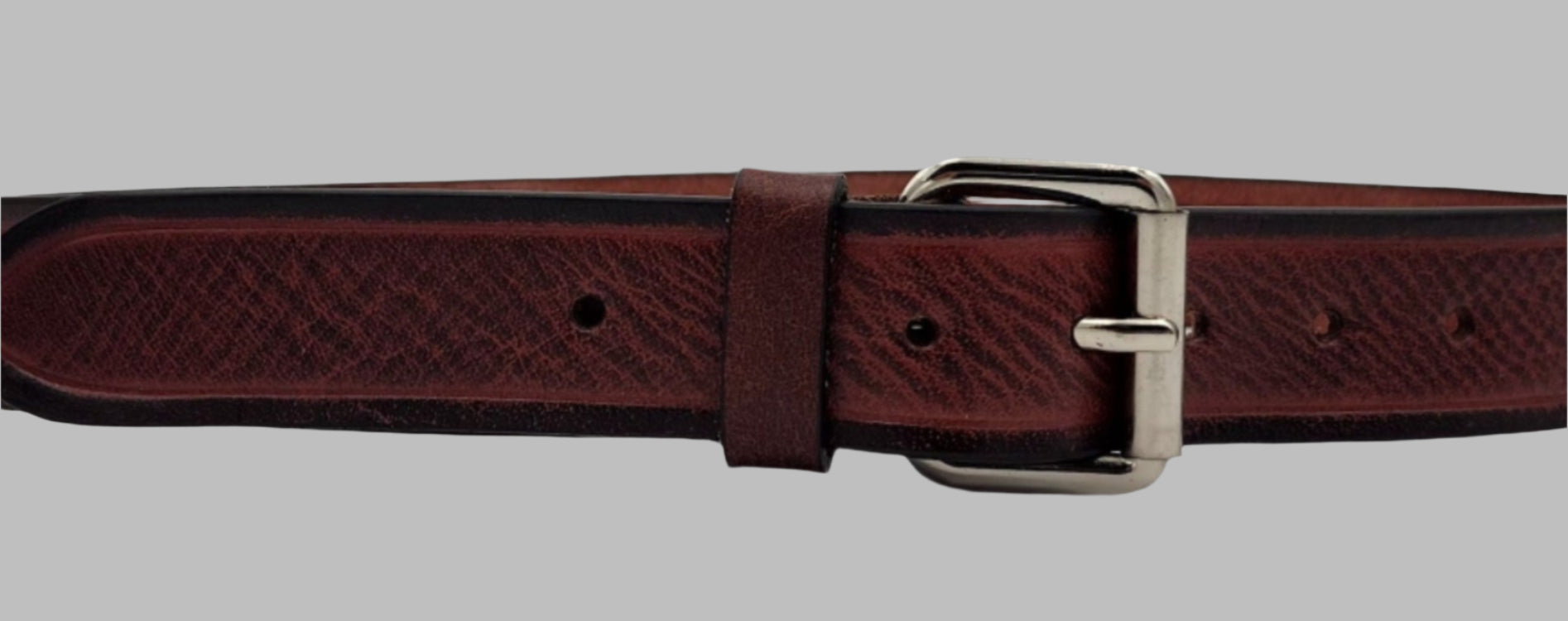 A cherry red leather belt with a metal buckle, displayed against a plain background.