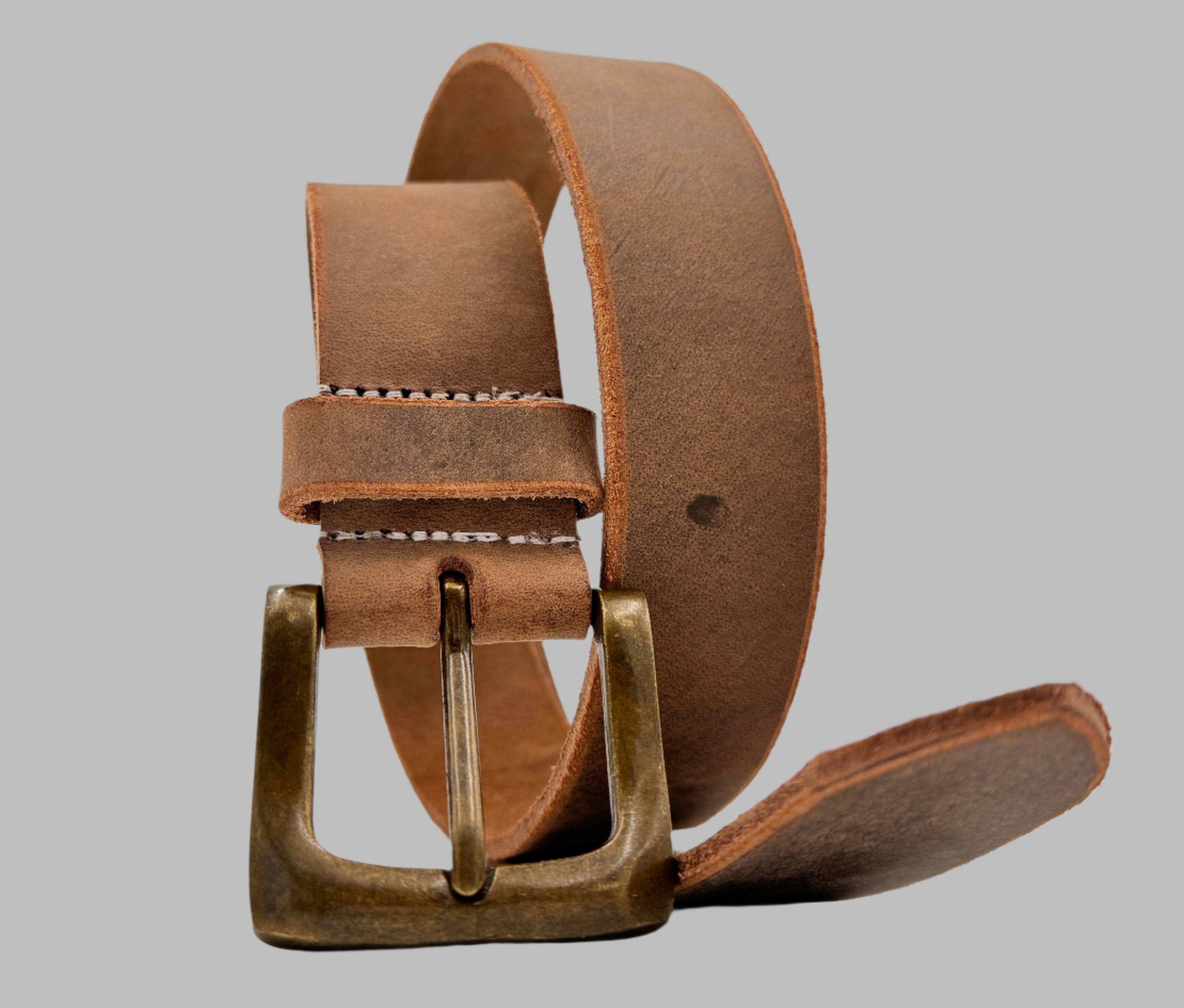 A brown full-grain leather belt with a metallic buckle, displayed on a plain background.