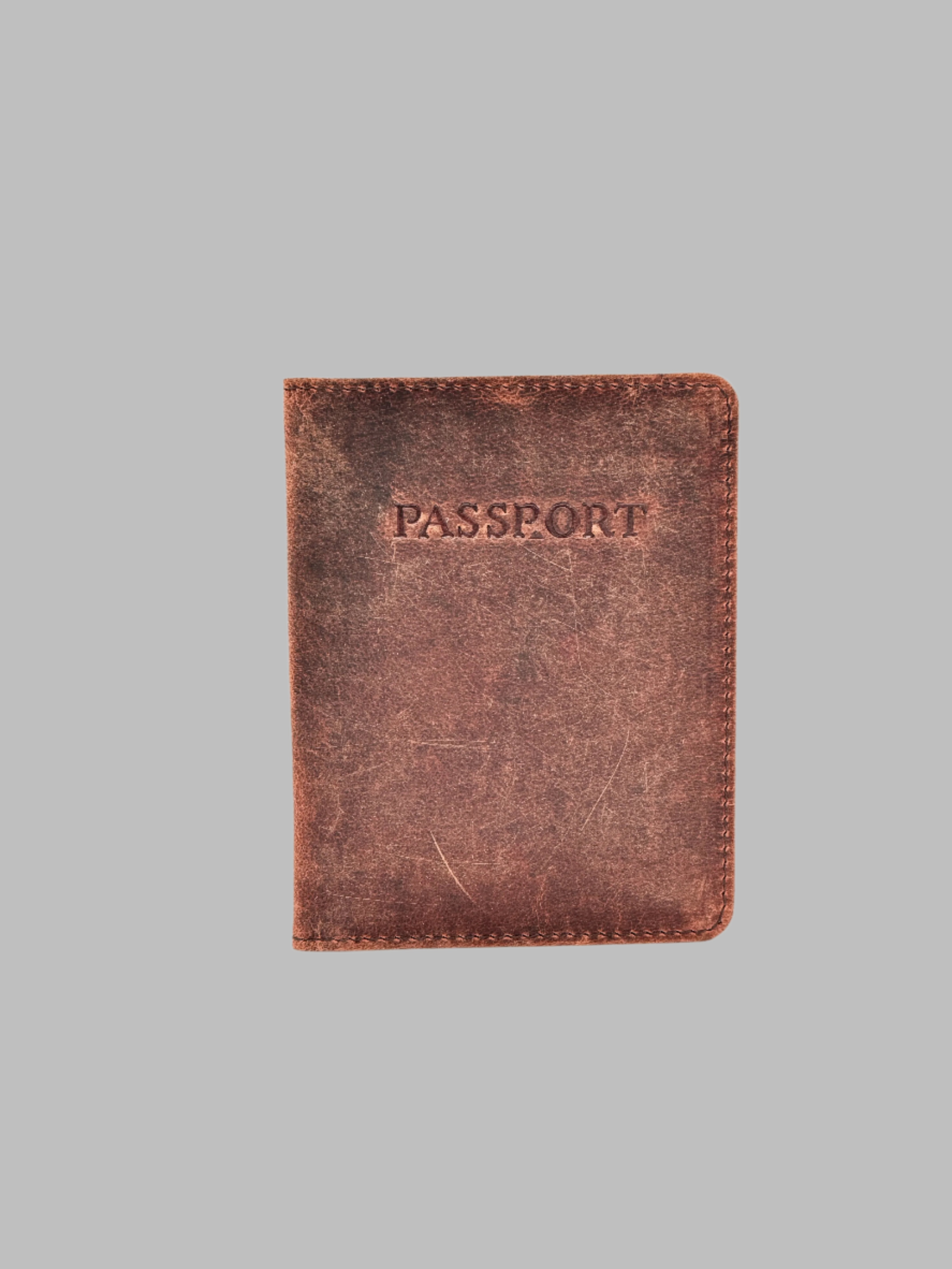 A brown genuine leather passport cover with the word 'PASSPORT' embossed on the front. It includes a card holder slot.