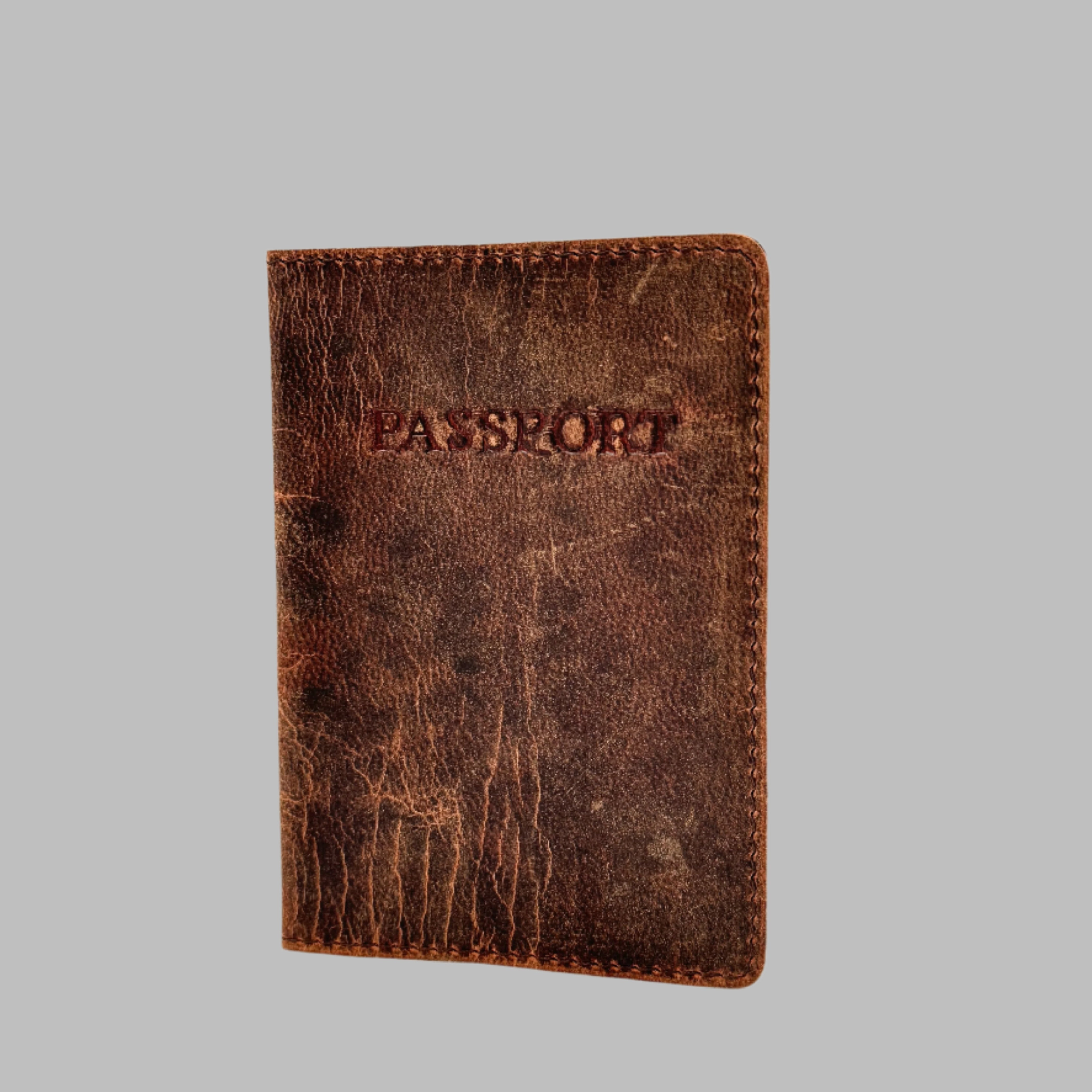 A brown leather passport cover with the word 'PASSPORT' embossed on the front.