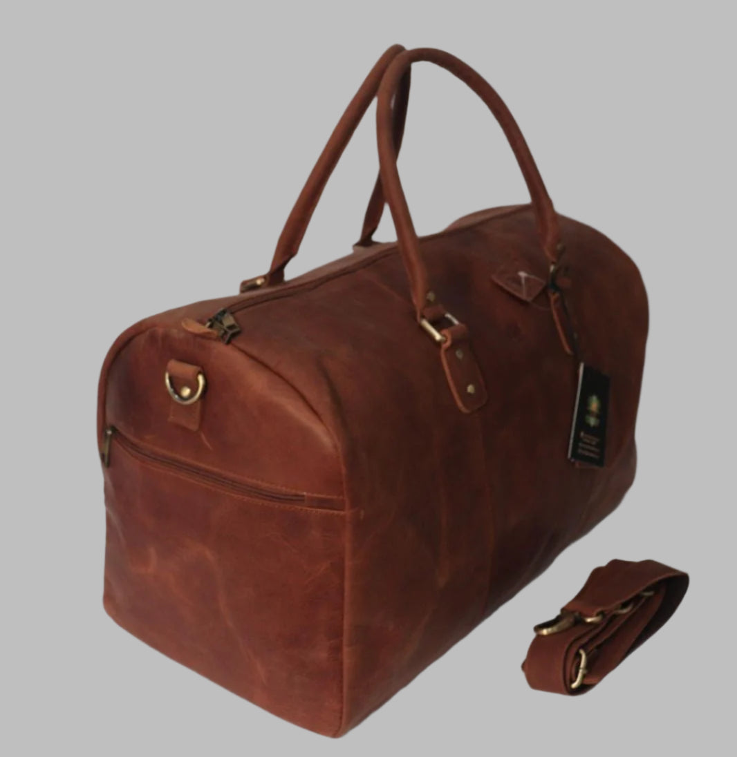 A brown leather duffle bag with a detachable shoulder strap and sturdy handles.