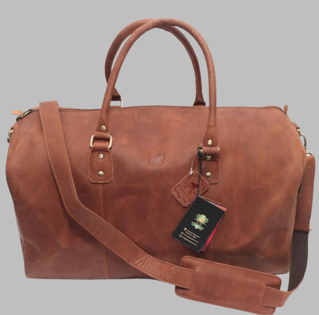 A brown leather duffle bag with a shoulder strap, front pocket, and metal hardware.