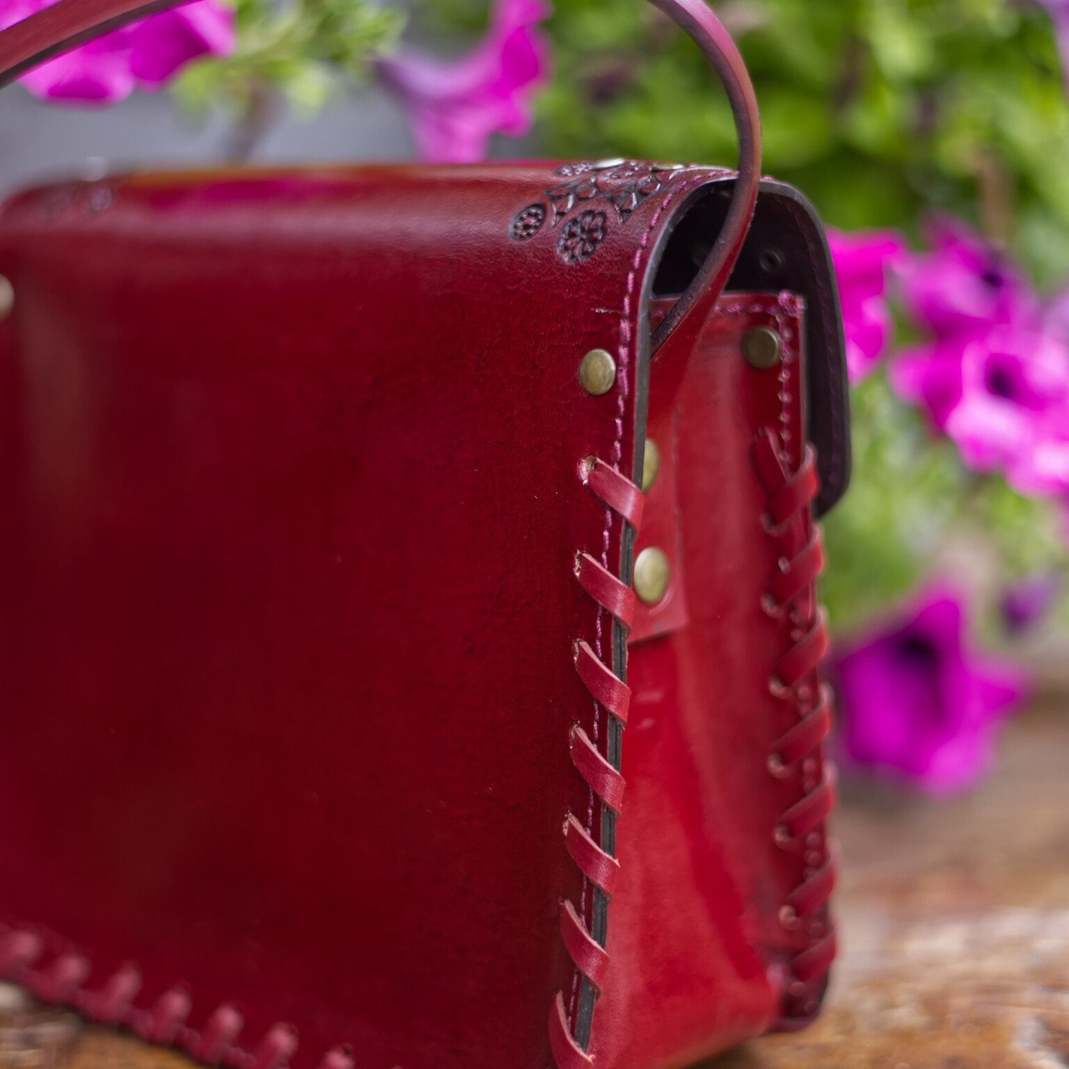 Red leather handbag with floral background