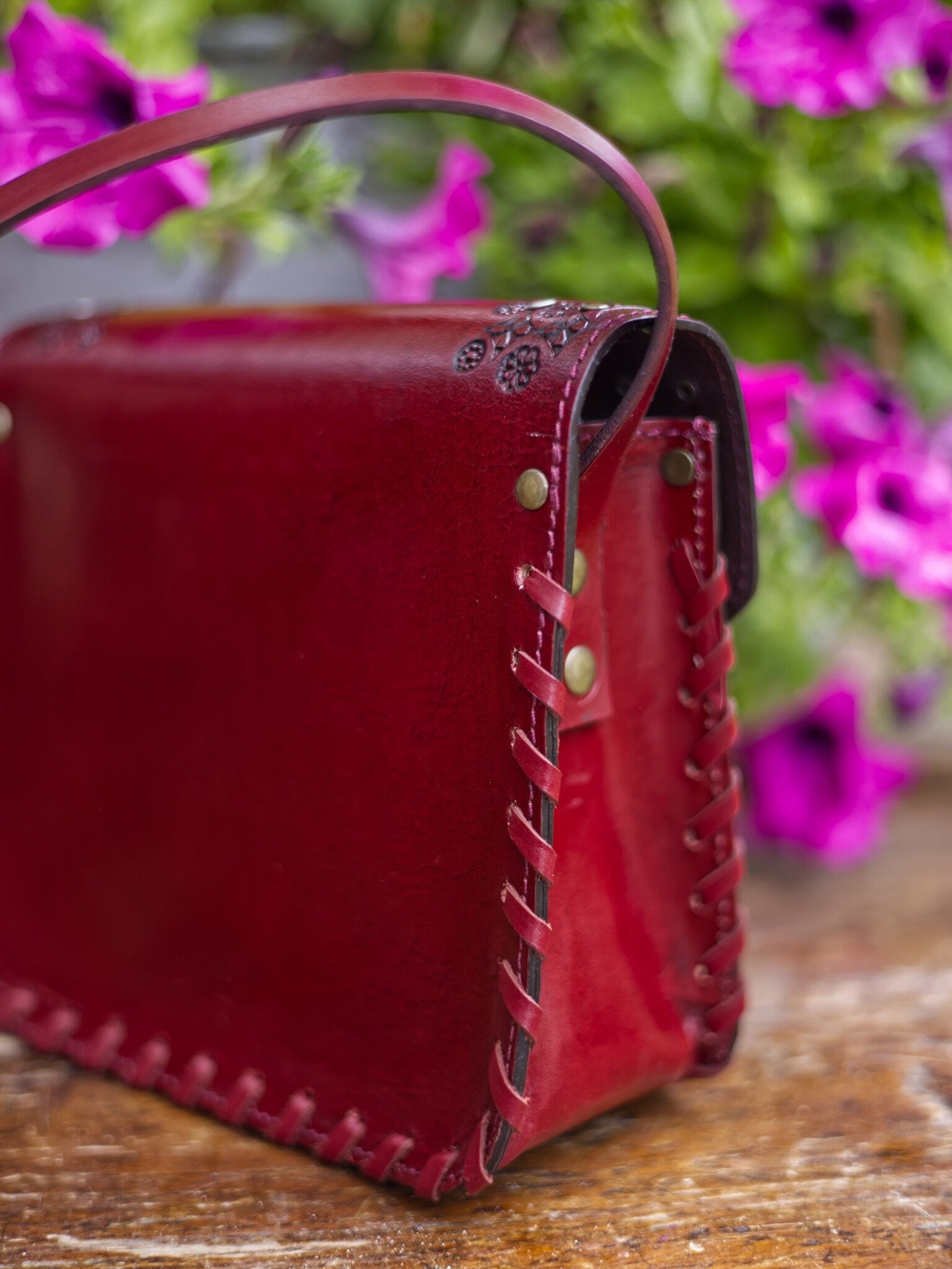 Red leather handbag with floral background