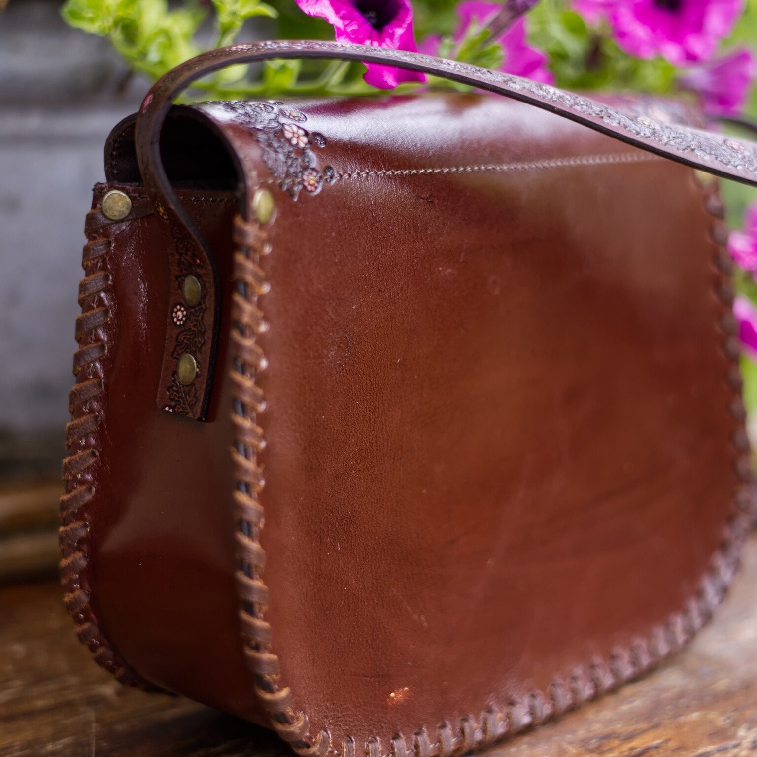 Brown leather bag with floral background