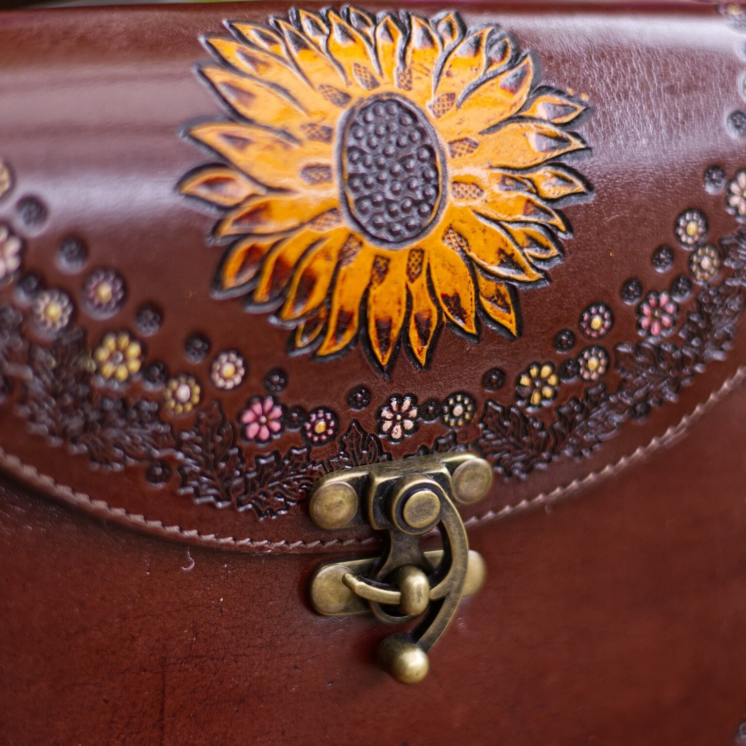 Brown leather bag with sunflower design and decorative elements