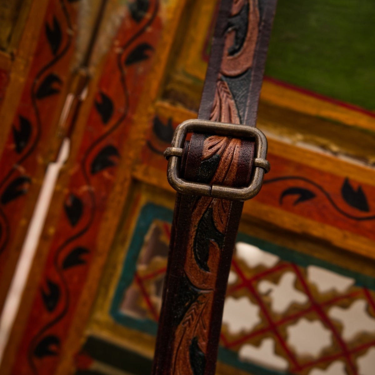 Decorative leather strap with intricate patterns on a colorful background