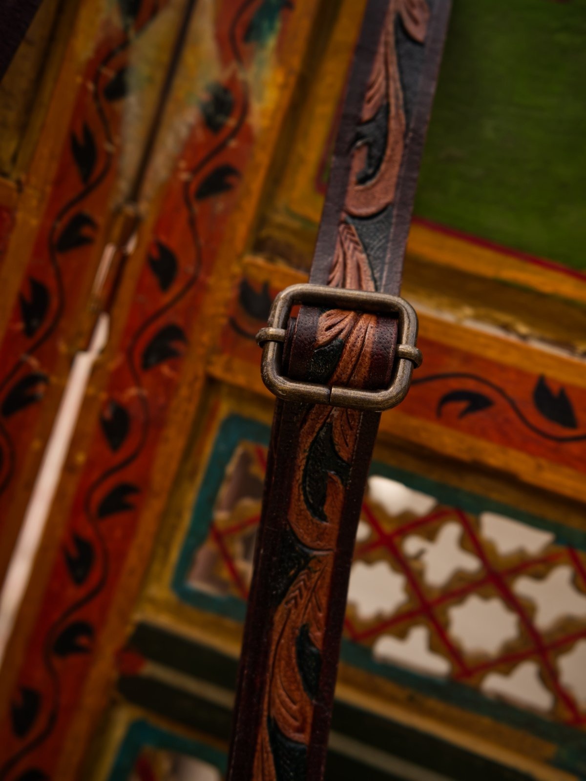 Decorative leather strap with intricate patterns on a colorful background
