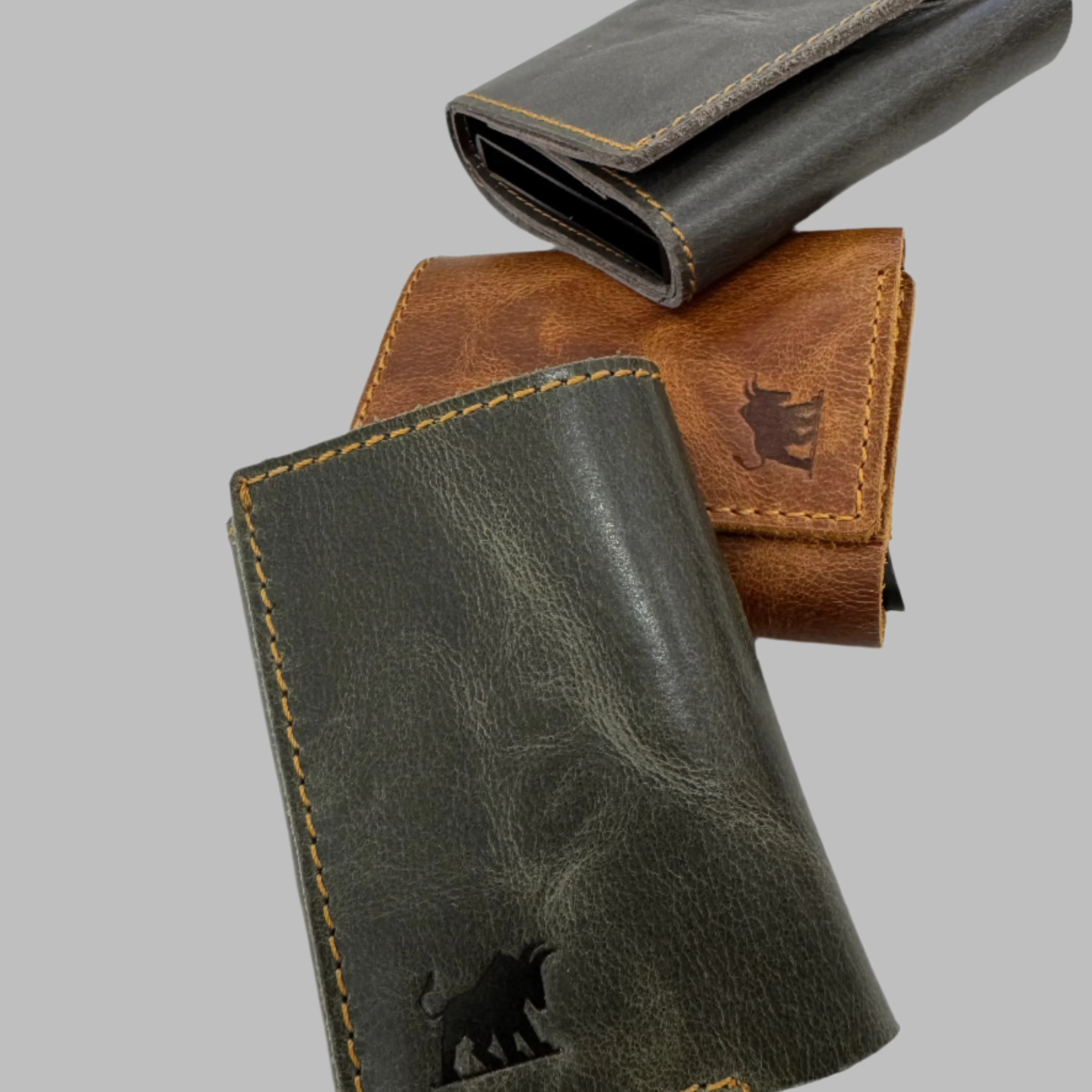 Three leather wallets with pop-up aluminum card cases, displayed in different colors.