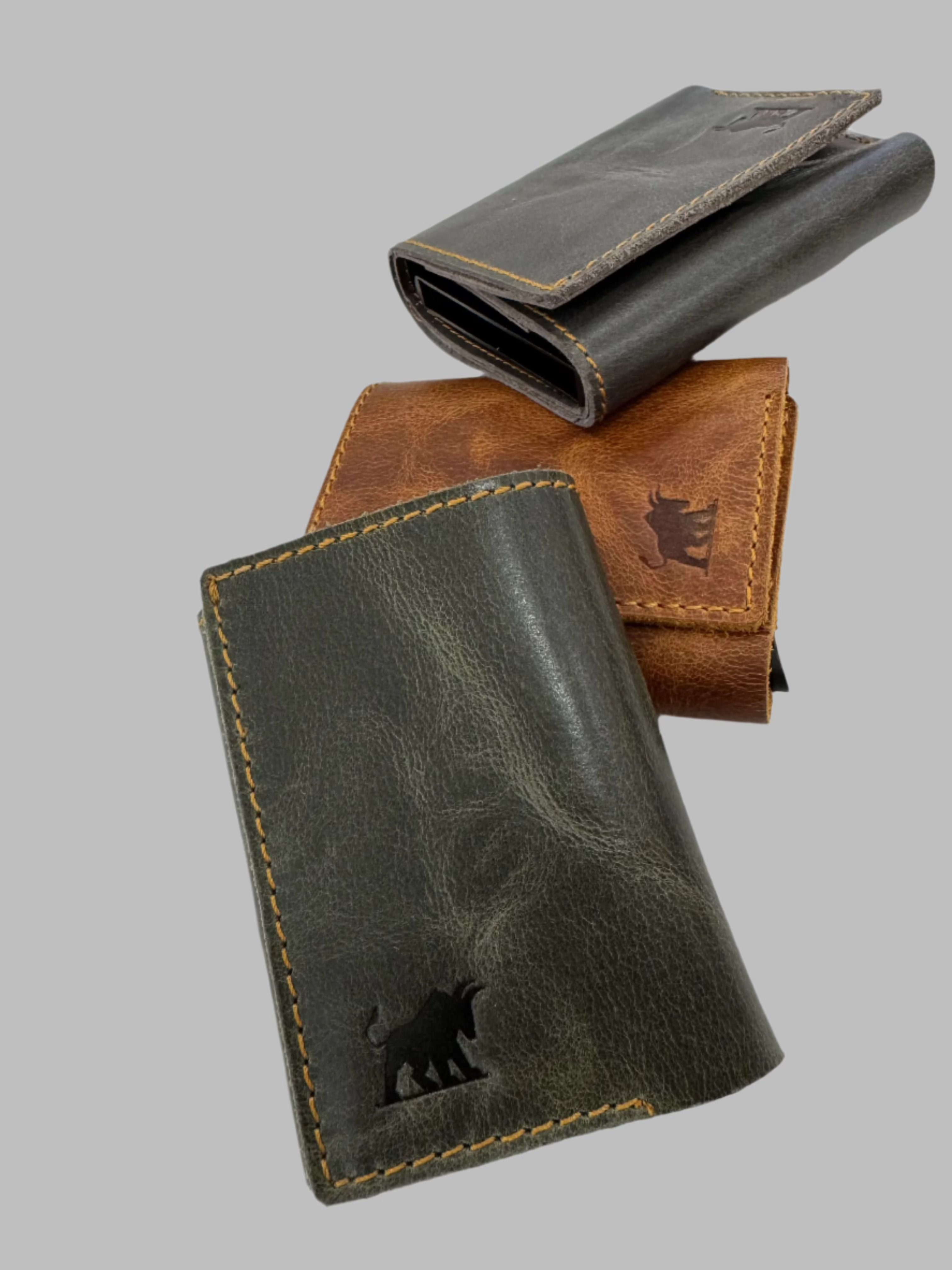 Three leather wallets with pop-up aluminum card cases, displayed in different colors.