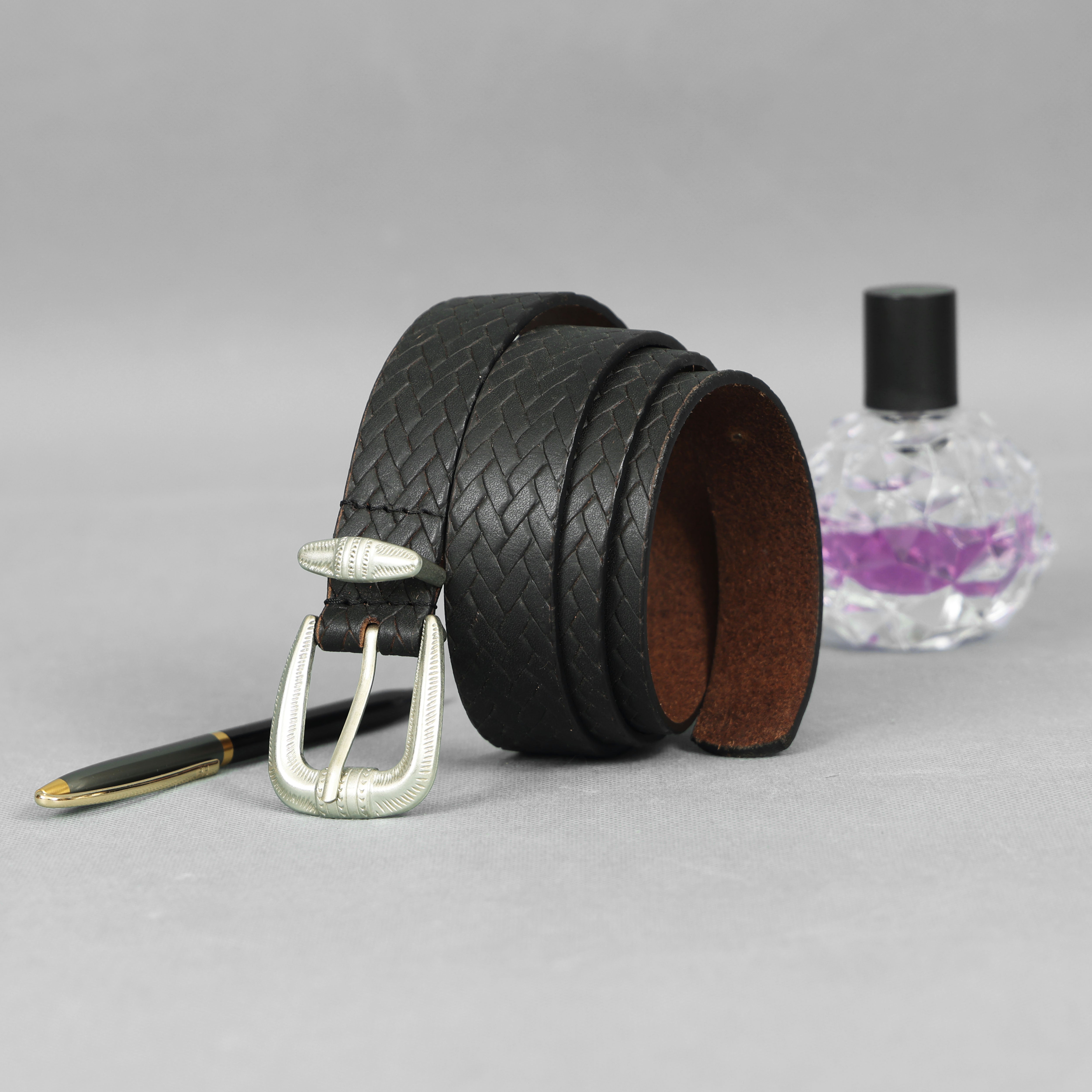 Black braided belt with silver buckle on a gray background