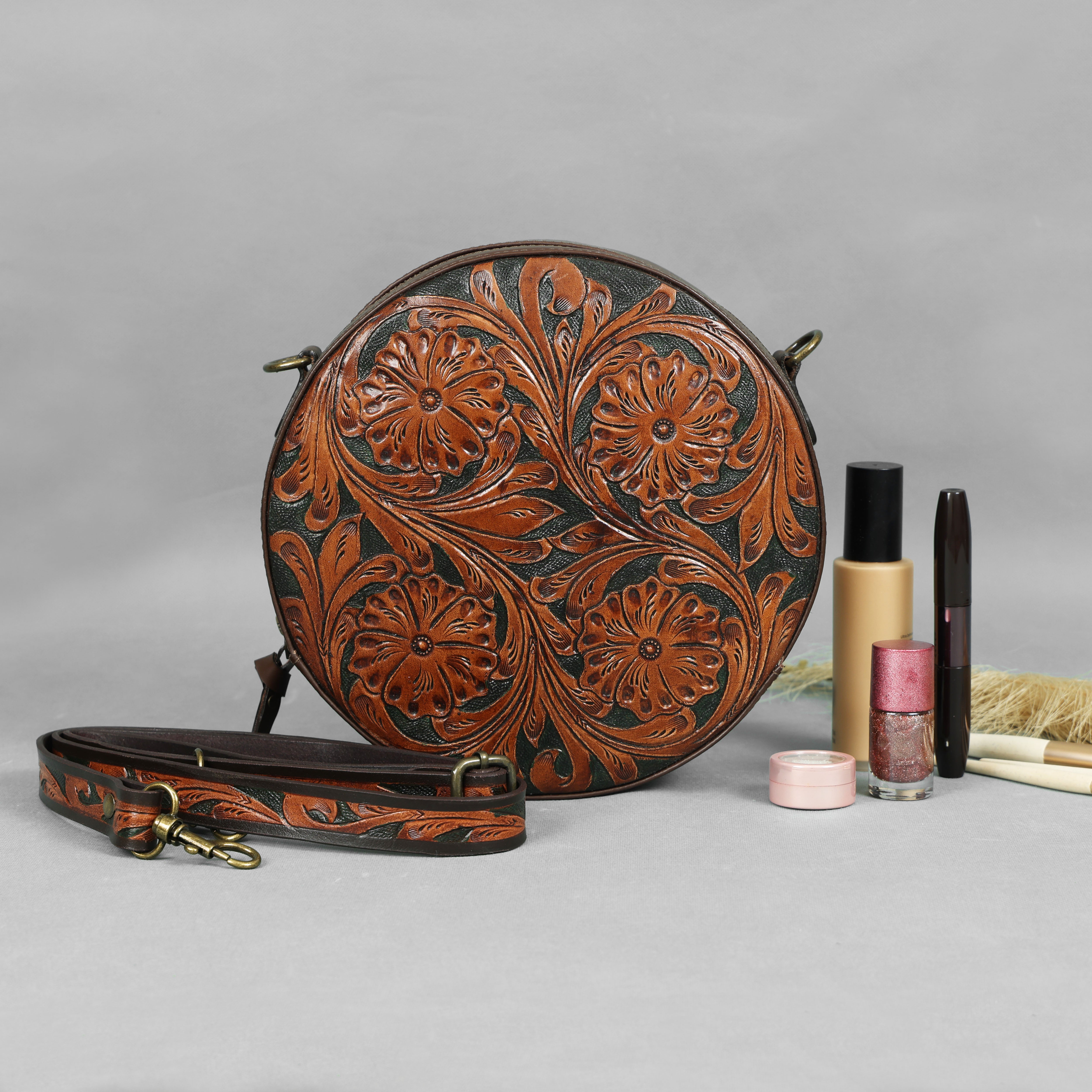 Round leather bag with floral patterns on a gray background