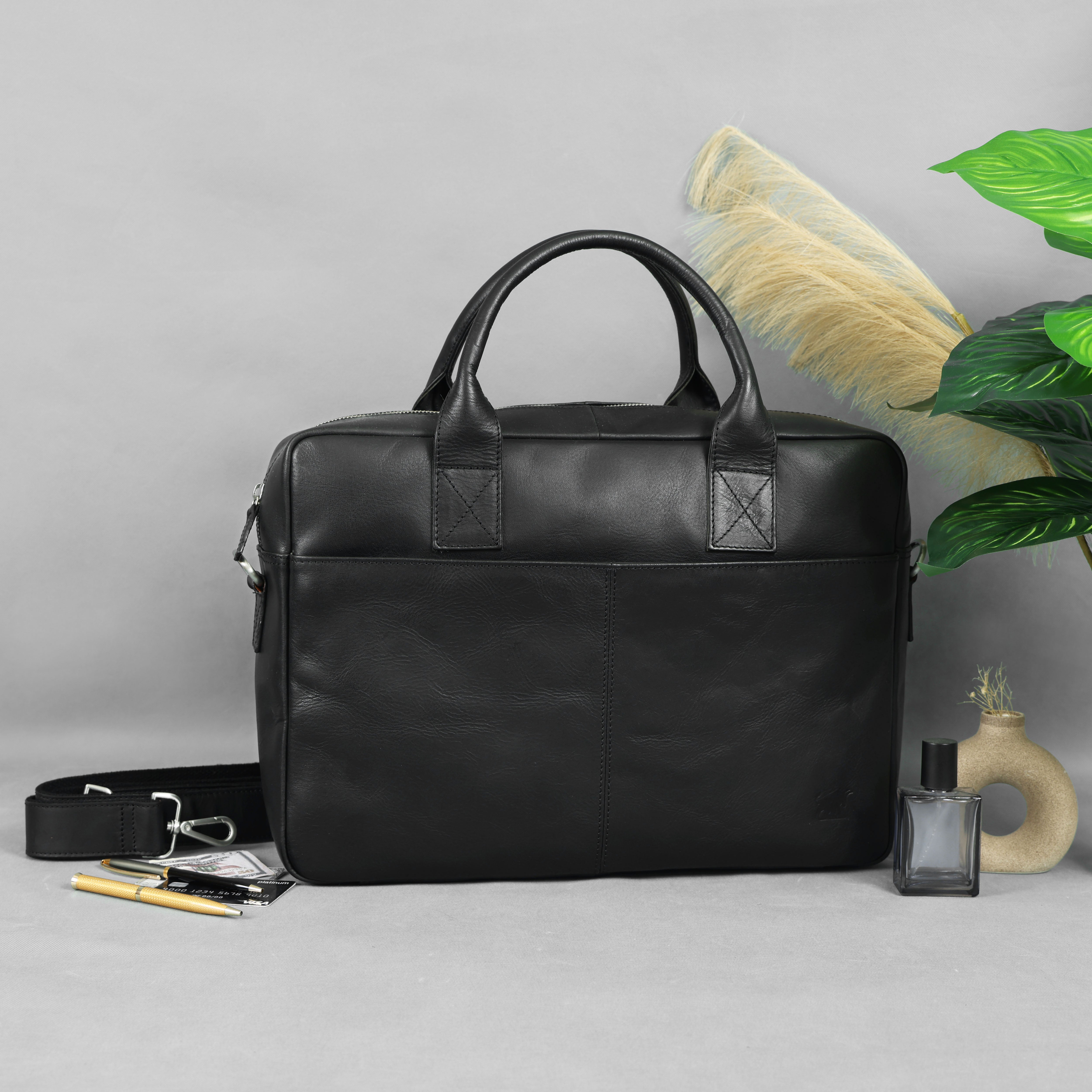 Black leather briefcase on a gray surface with decorative elements