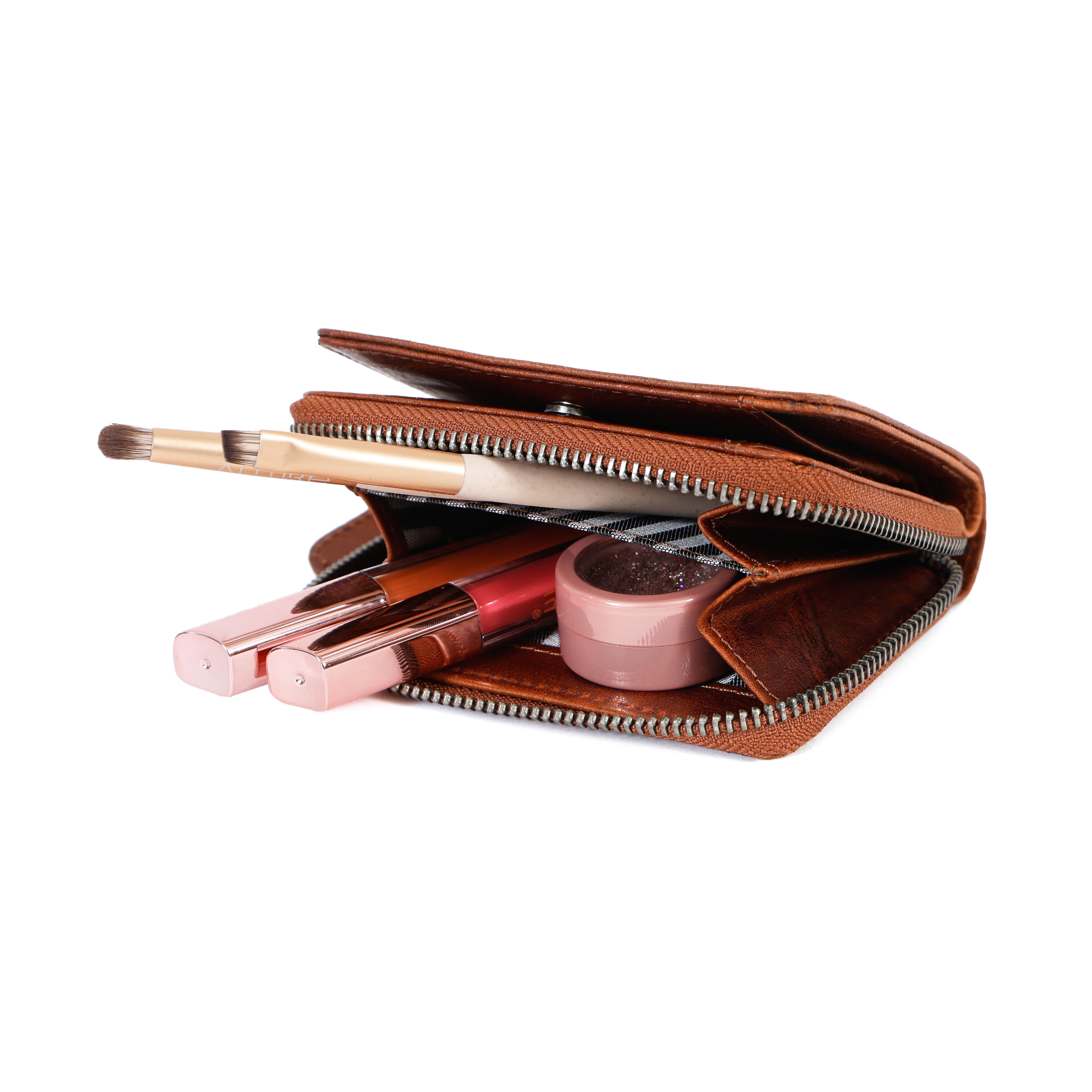Open brown wallet with makeup items on a white background