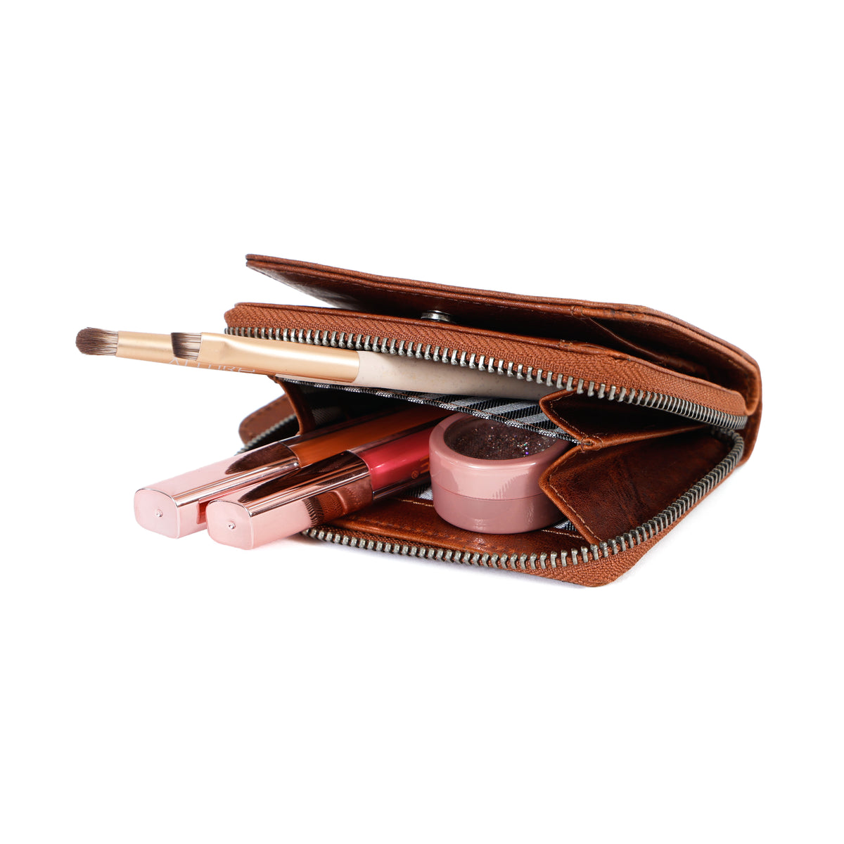 Open brown wallet with makeup items on a white background