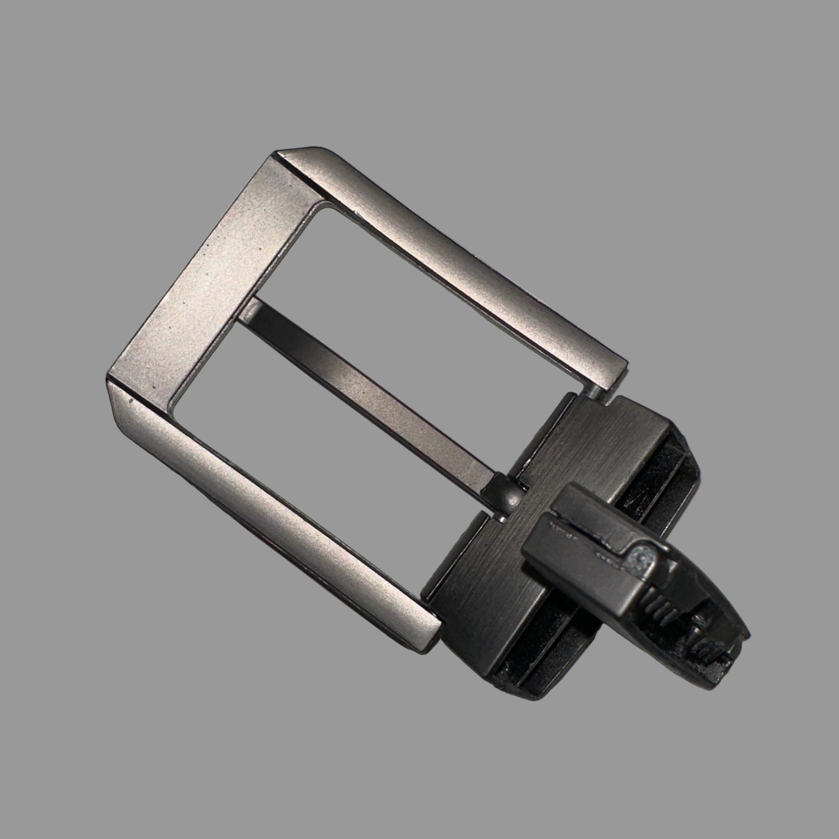 Metallic watch buckle on a gray background