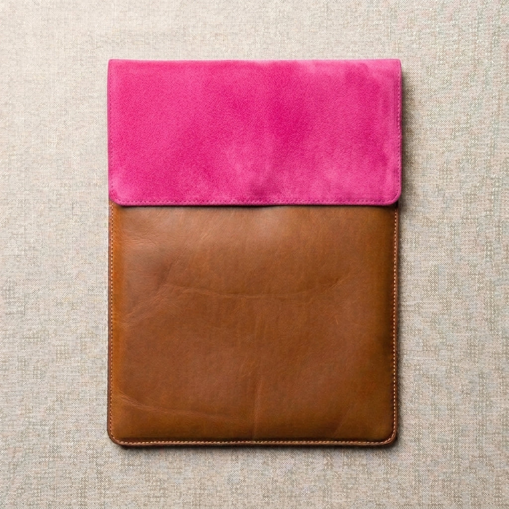 A laptop sleeve featuring a bright pink suede flap and a brown leather.