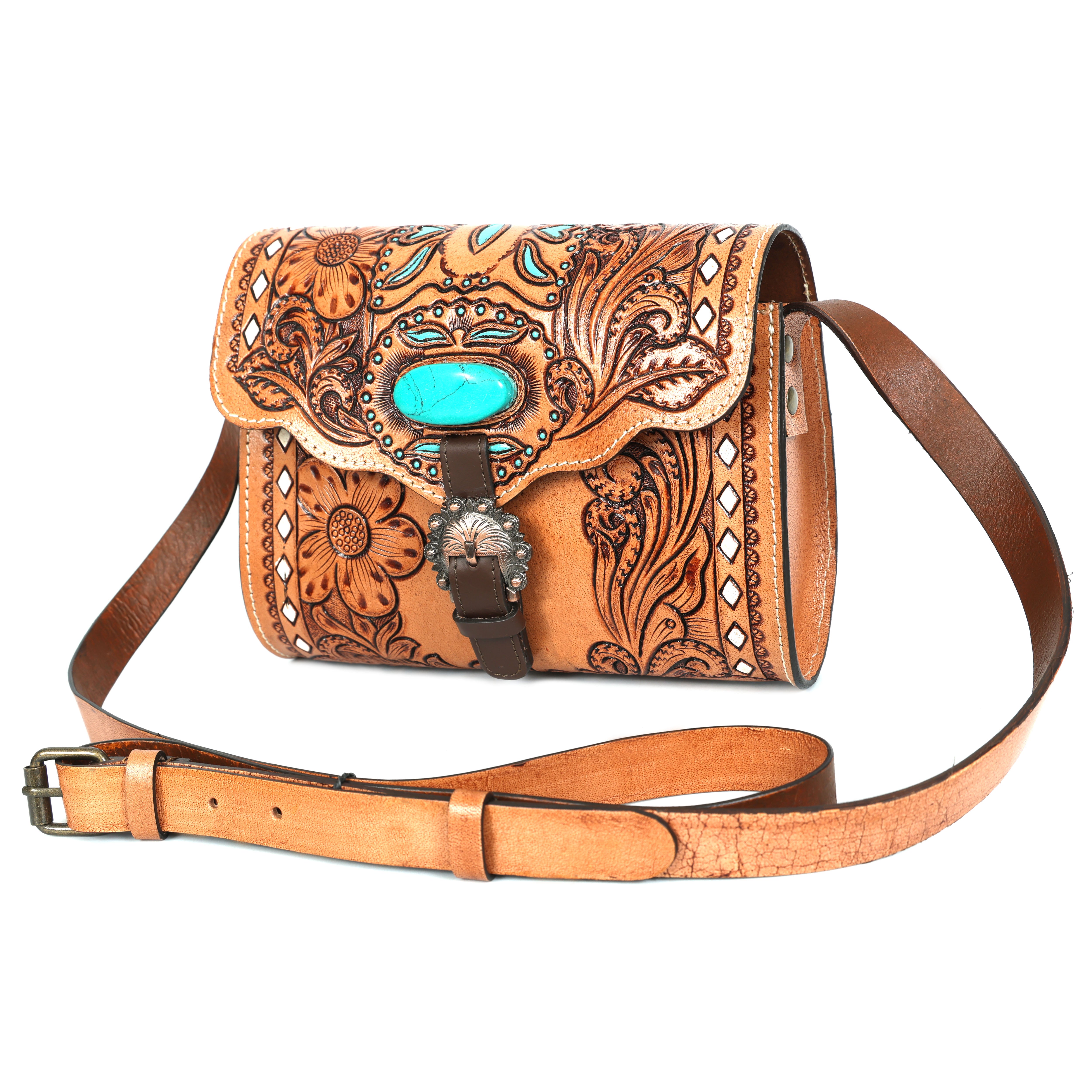 A tan, hand-tooled genuine leather crossbody bag featuring a Western floral design, a large oval turquoise stone on the flap, and a decorative silver buckle.
