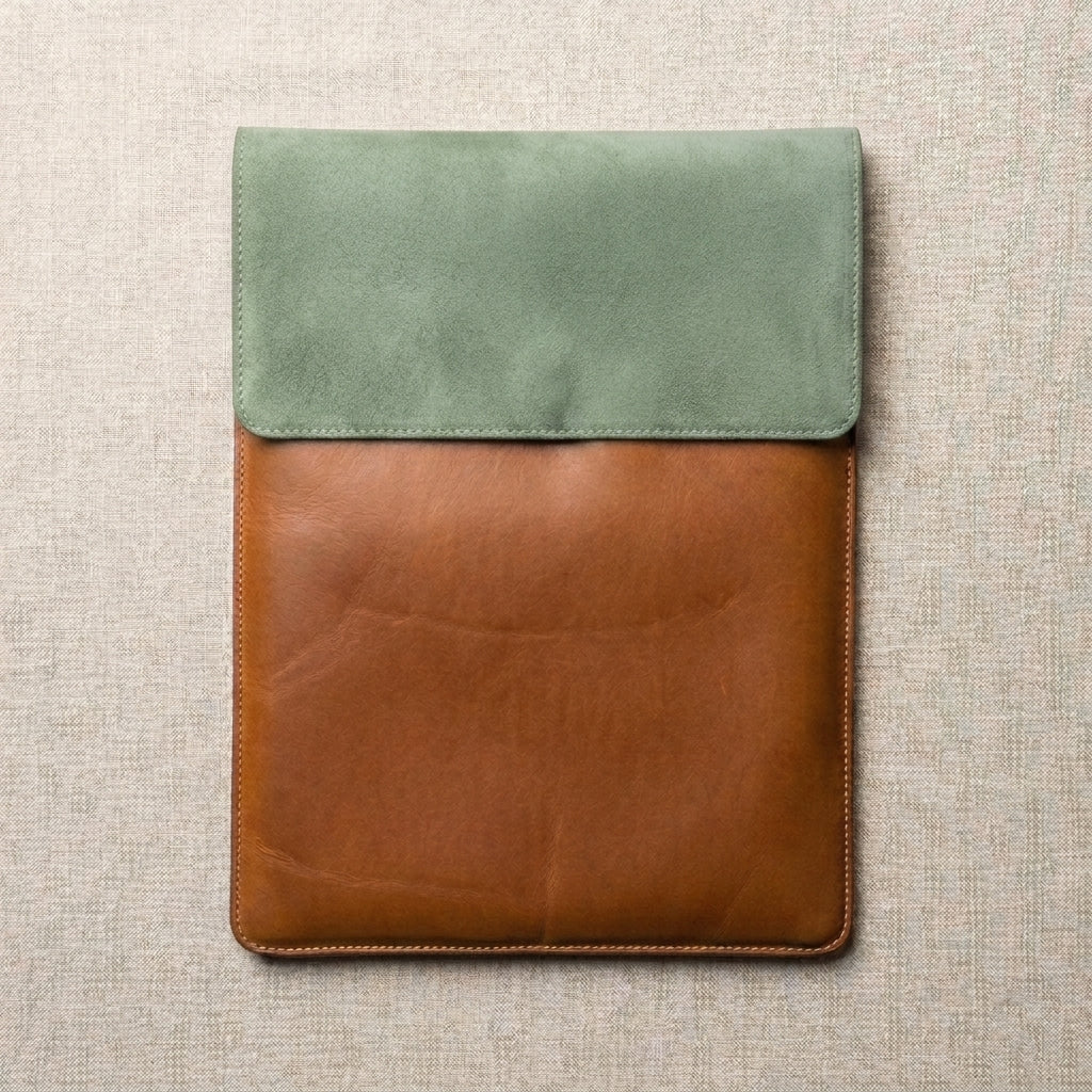 Leather two-tone laptop/ablet sleeve featuring a sage green suede flap and a brown leather body,