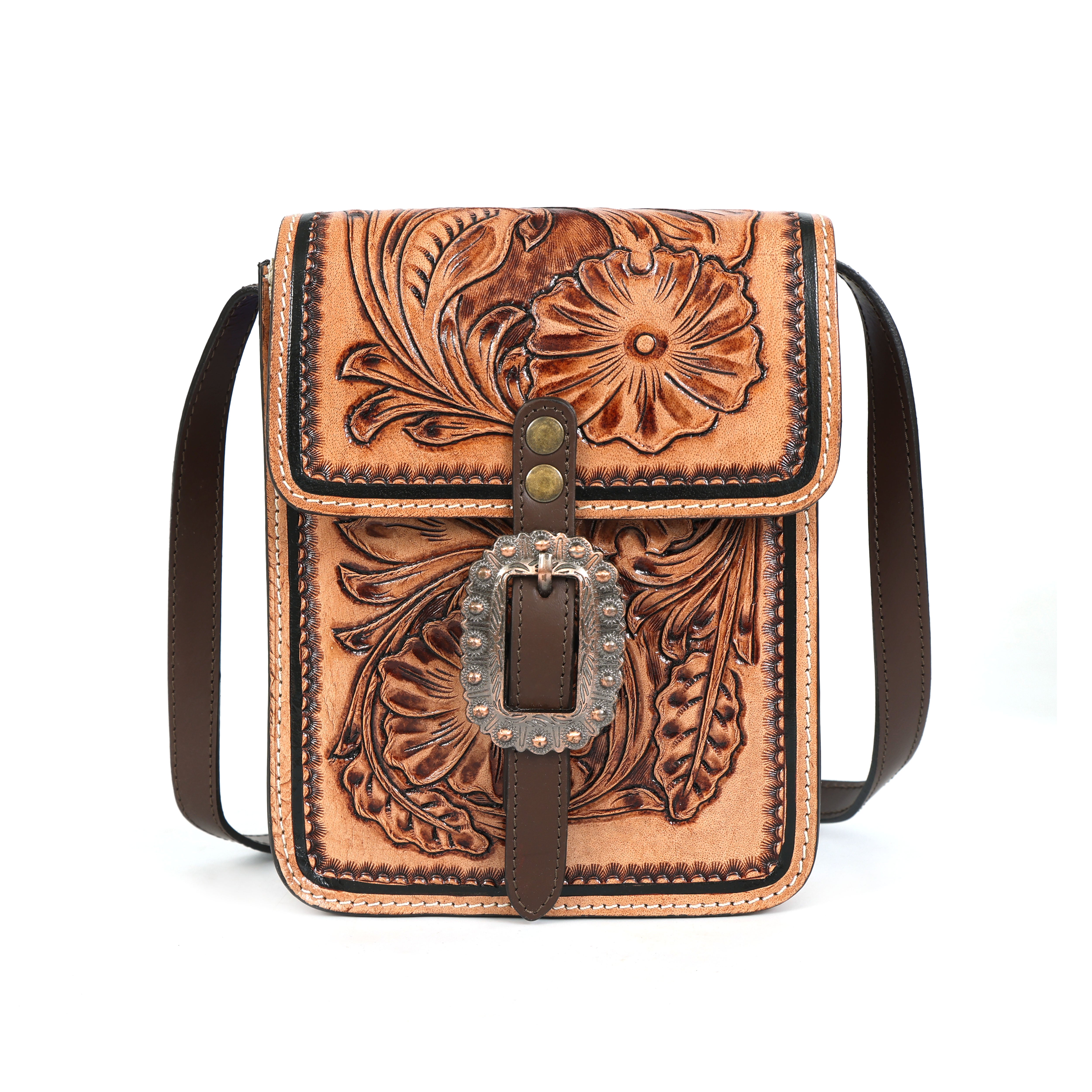 Brown leather crossbody bag with intricate floral tooling and a metal buckle on a white background