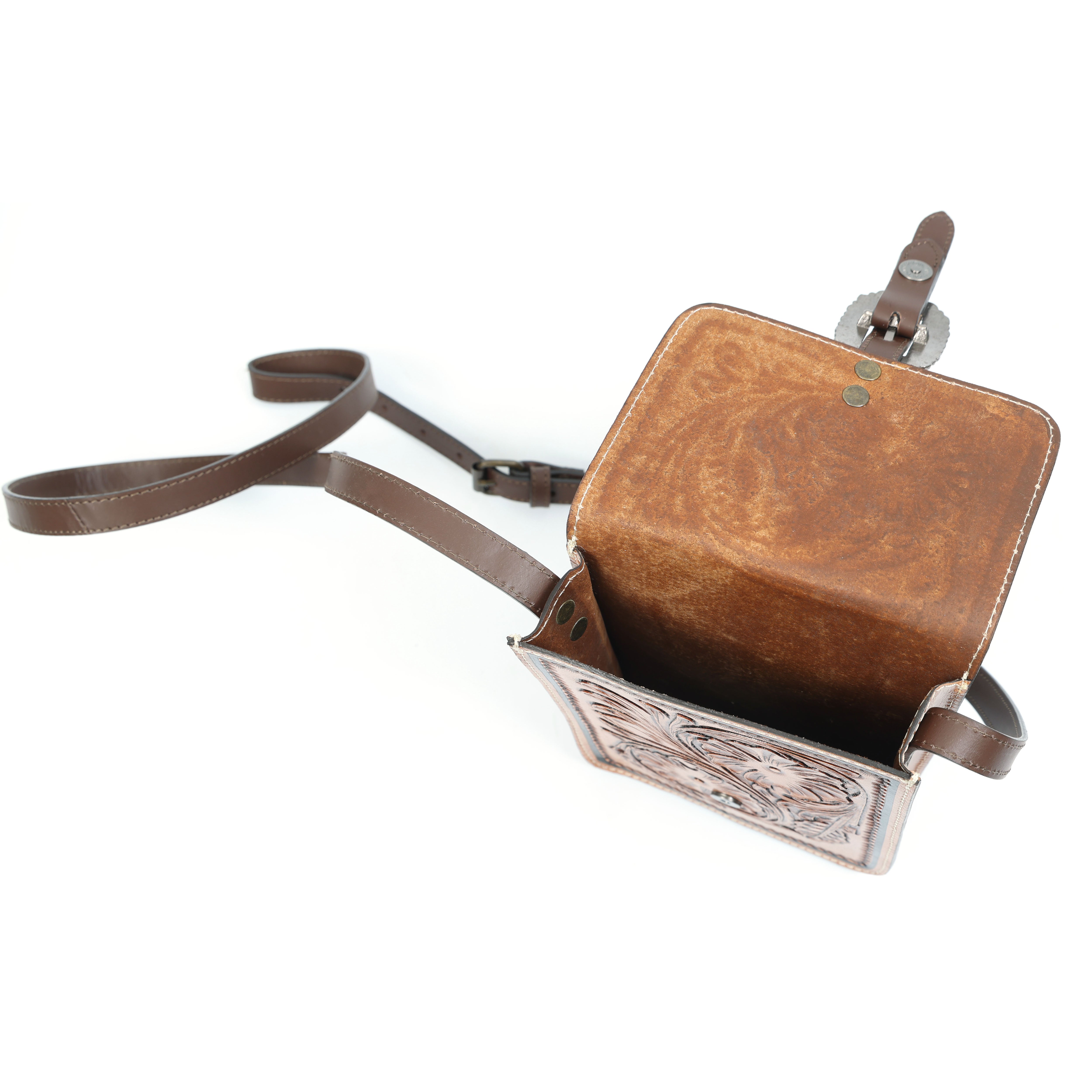 GM Leather Auckland artisan floral tooled leather small crossbody sling bag with adjustable strap and vintage buckle closure, photographed on a white background