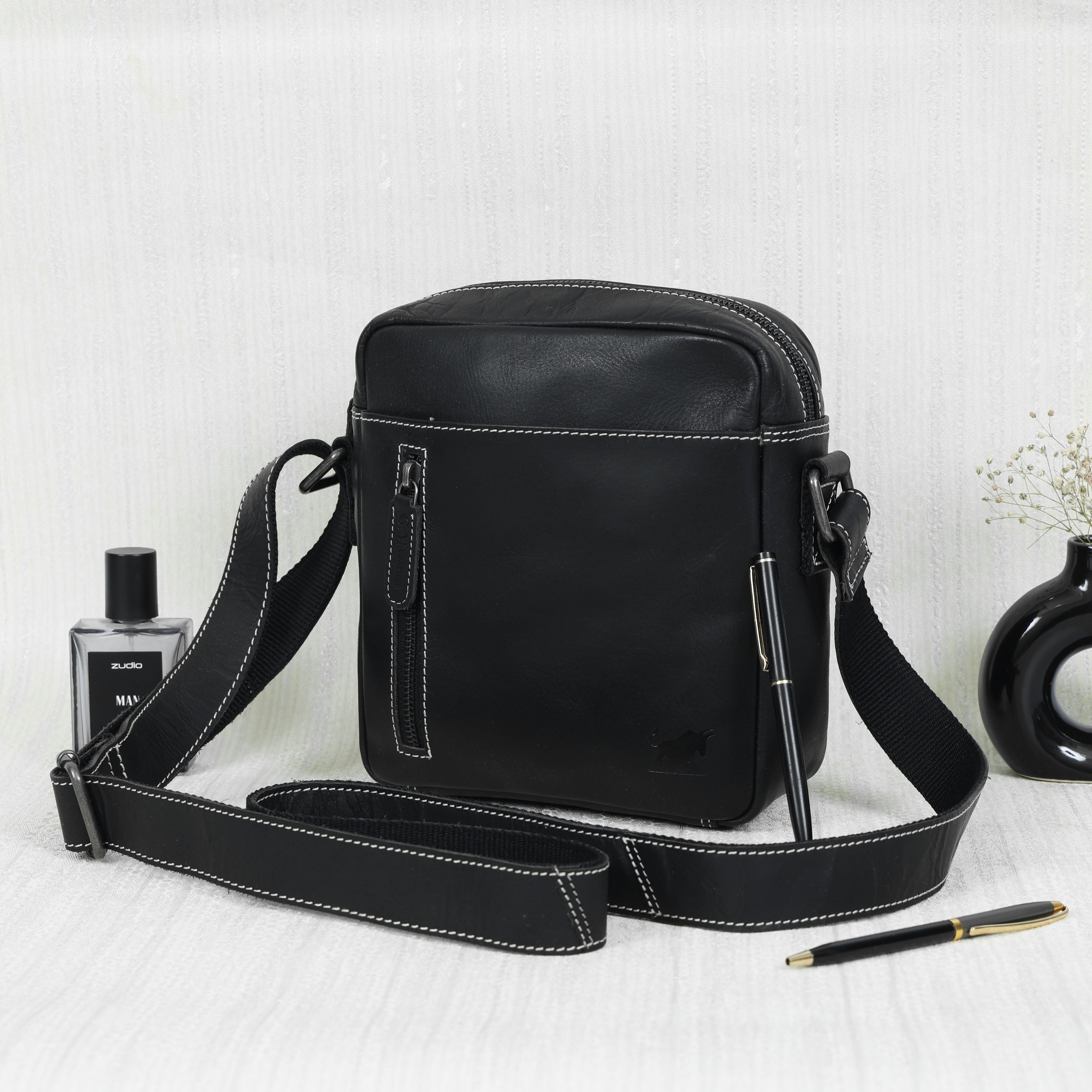 GM Leather small black leather vertical sling bag/crossbody with white contrast stitching, secure zip closure, and adjustable strap, Auckland.