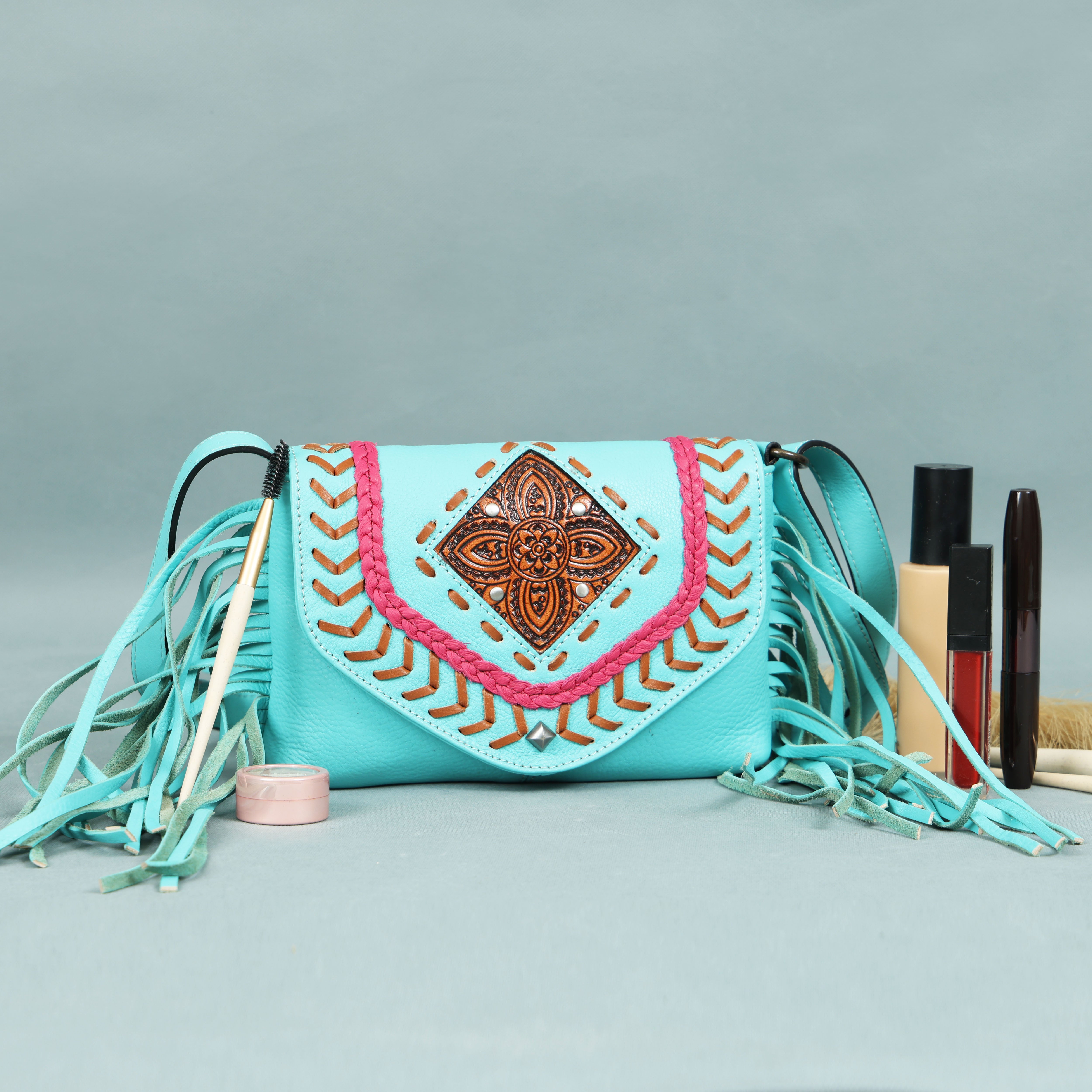 Turquoise genuine leather fringe crossbody bags in black, turquoise, brown, and white, featuring braided trim and a central carved medallion, by GM Leather Auckland