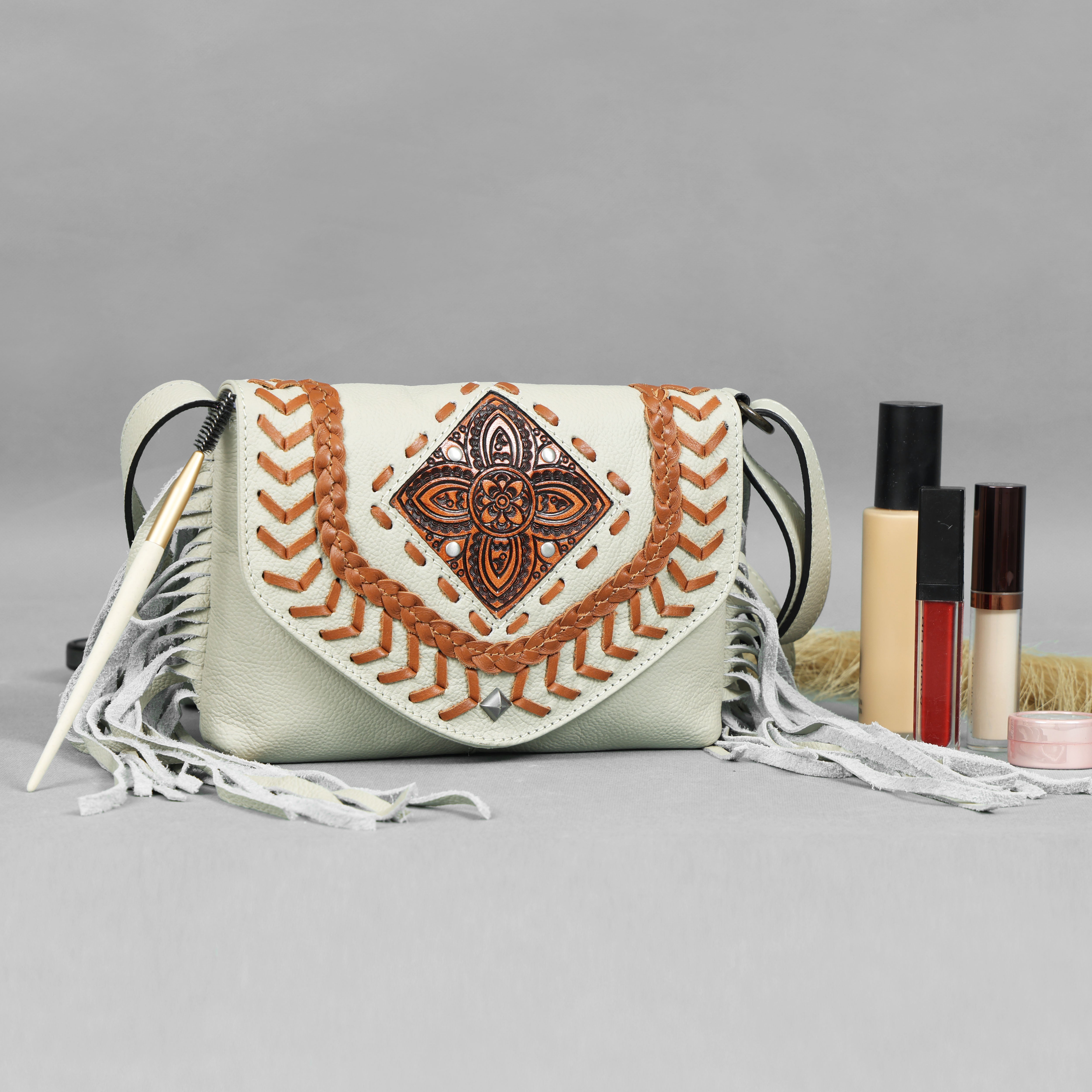 Beige genuine leather fringe crossbody bags in black, turquoise, brown, and white, featuring braided trim and a central carved medallion, by GM Leather Auckland