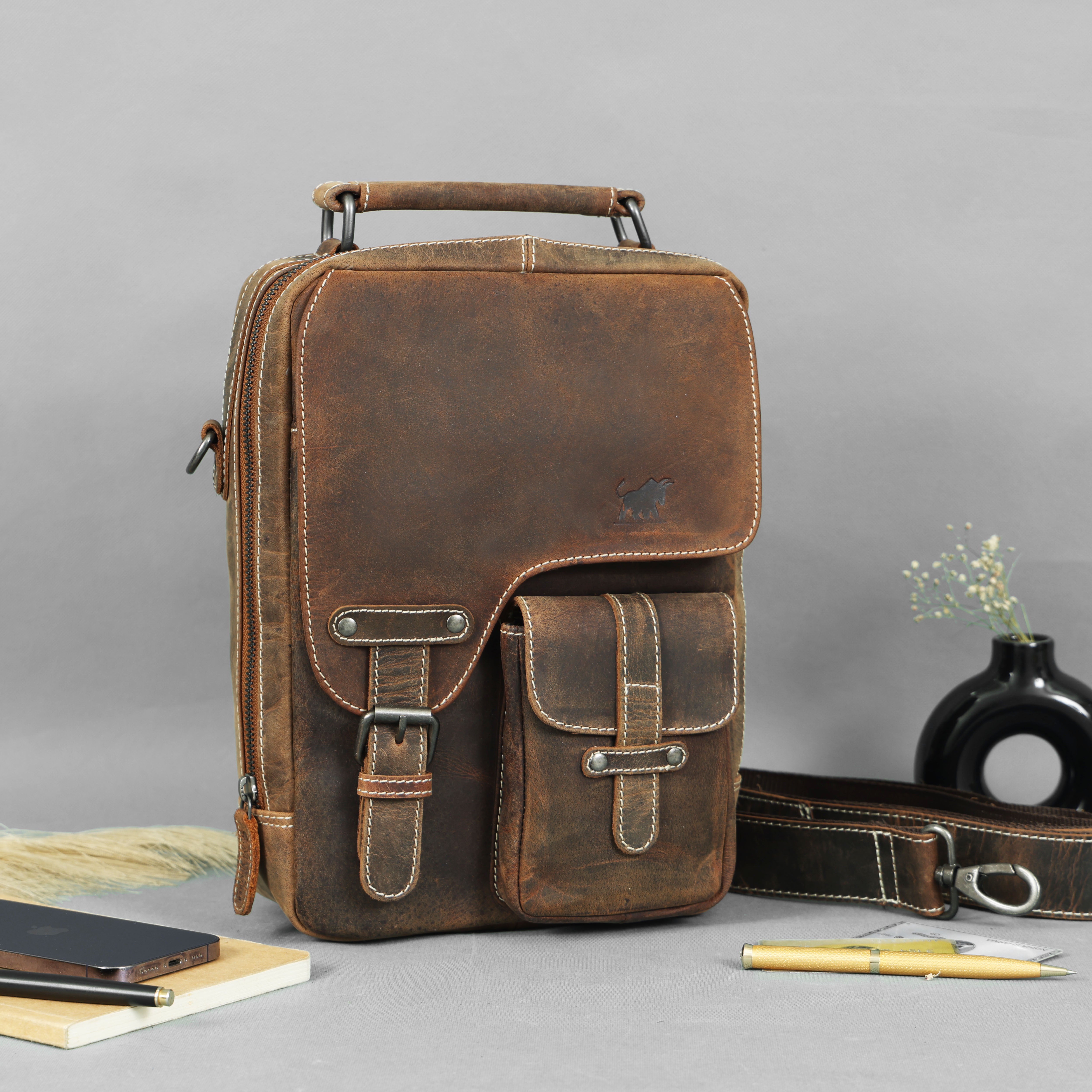 Brown leather sling bag with front pockets and adjustable strap handcrafted by GM Leather Auckland, designed as a premium crossbody messenger for everyday use