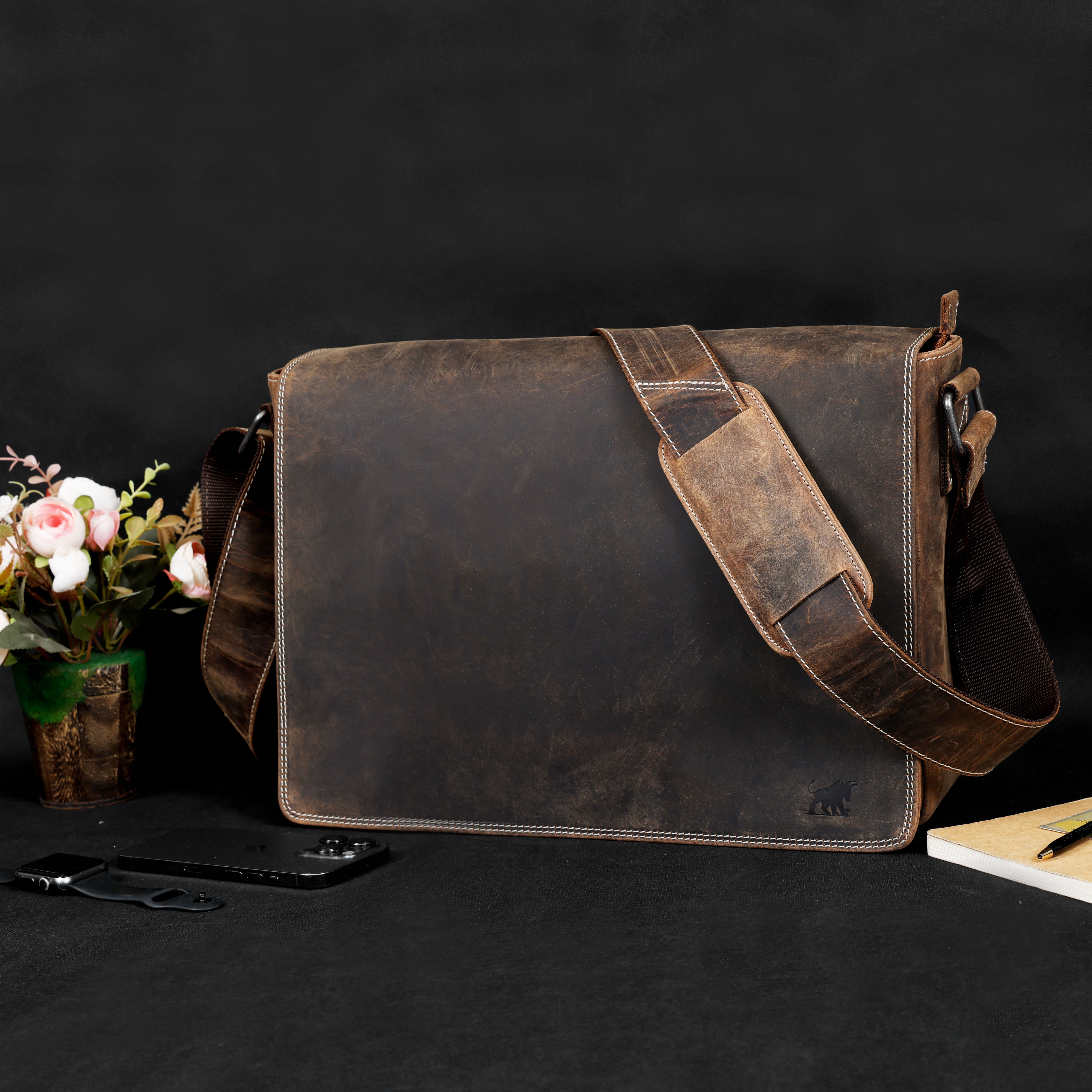 A premium GM Leather distressed brown messenger bag with a wide adjustable shoulder strap and visible stitching, handcrafted quality available at LynnMall, Auckland.