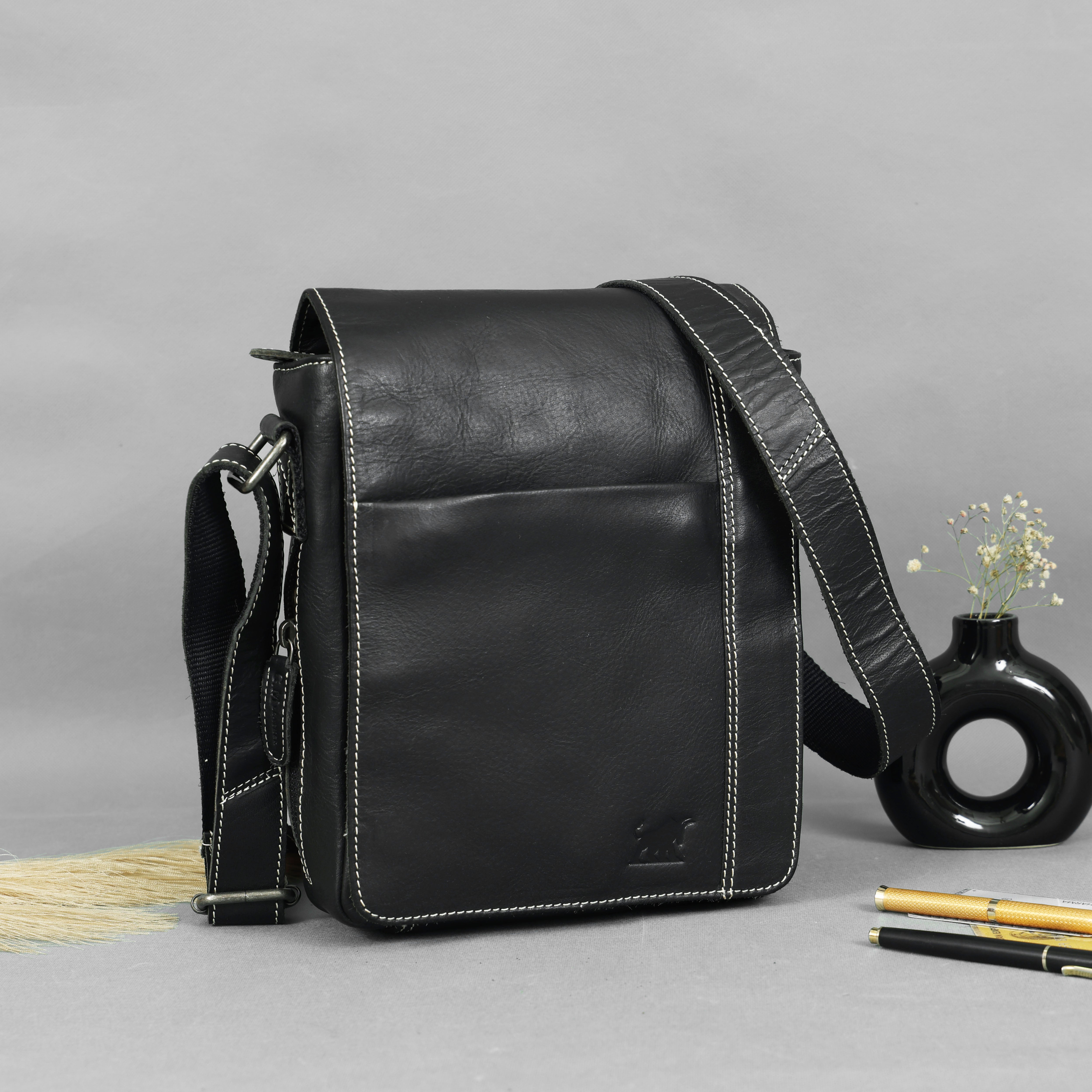 Premium light grey genuine leather mini crossbody bag with a front zip pocket and canvas strap, styled on a grey background by GM Leather Auckland.