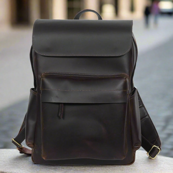 GM Leather Auckland men's dark brown full-grain leather flap backpack, ideal laptop bag for work or travel, available for purchase at Lynnmall New Lynn NZ.